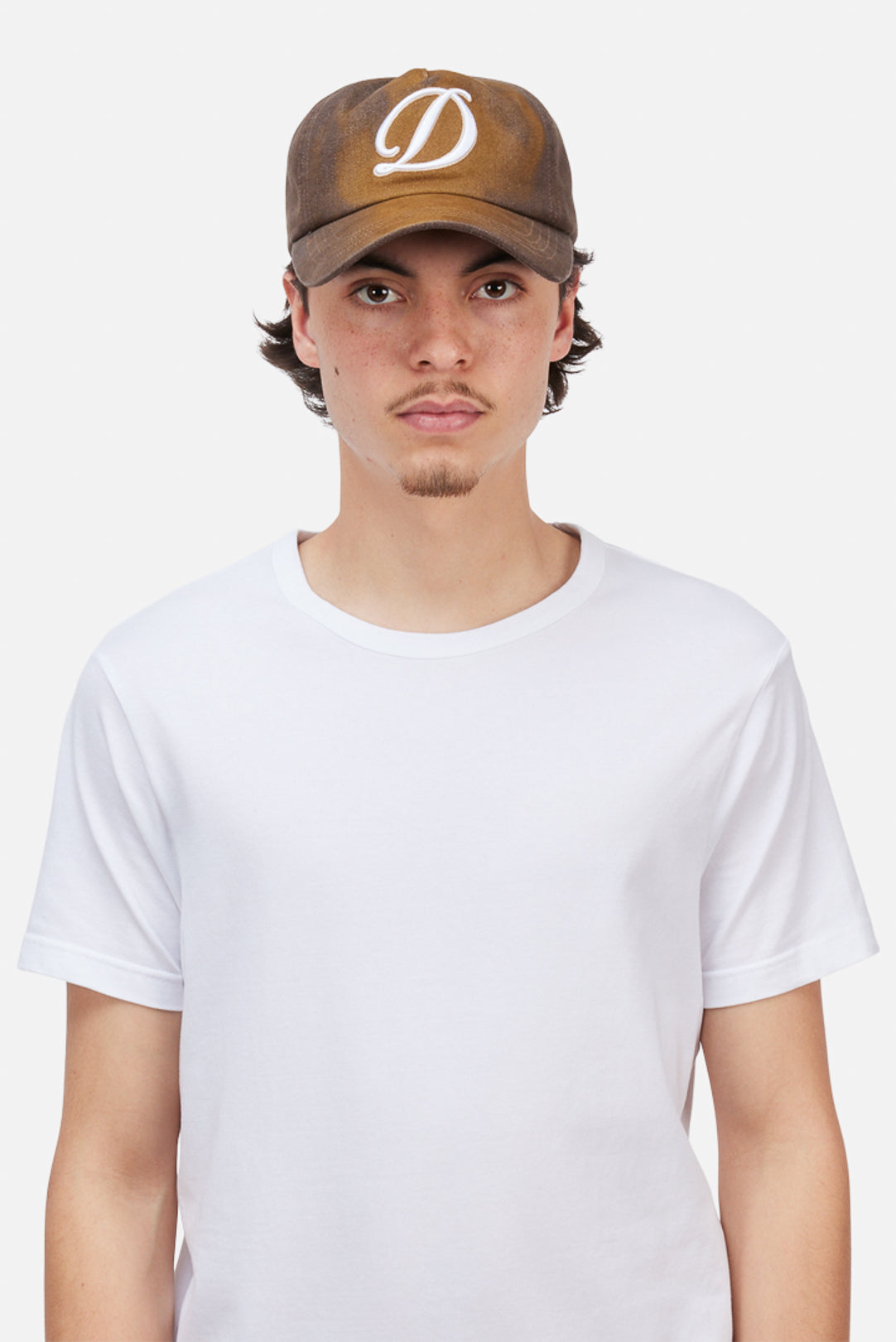 Model wearing the Dime MTL Cursive Denim Worker Cap in Brown Washed