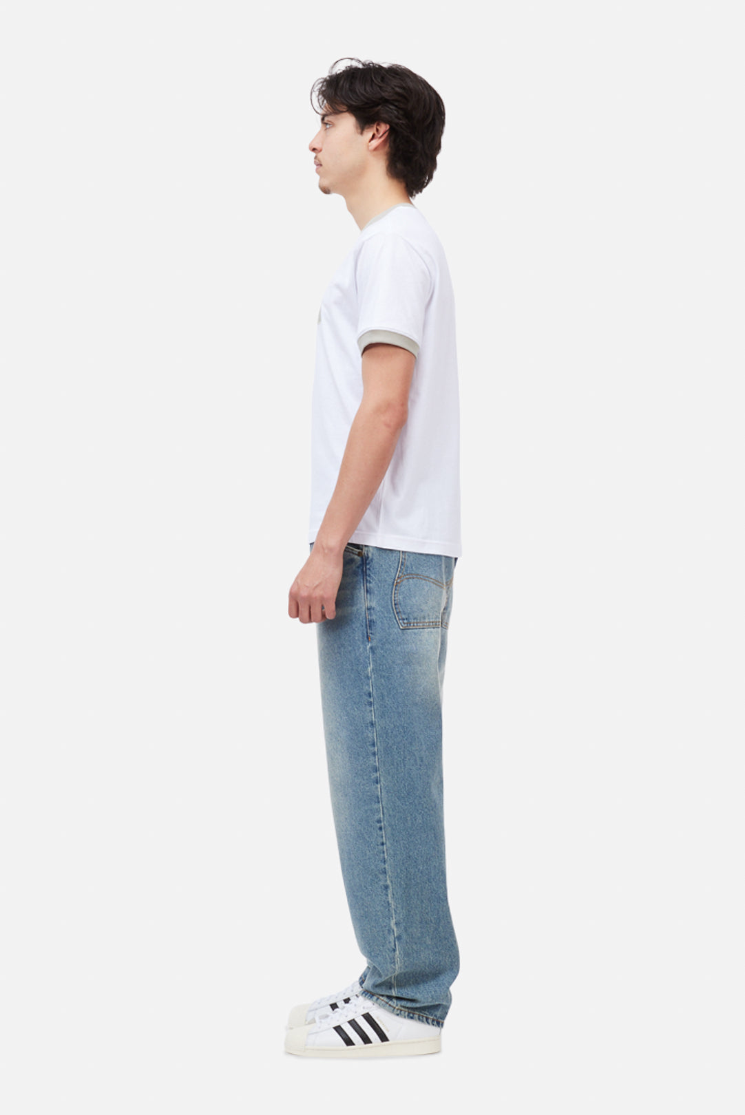 Model wearing the Dime MTL Arch Ringer T-Shirt in White, side view