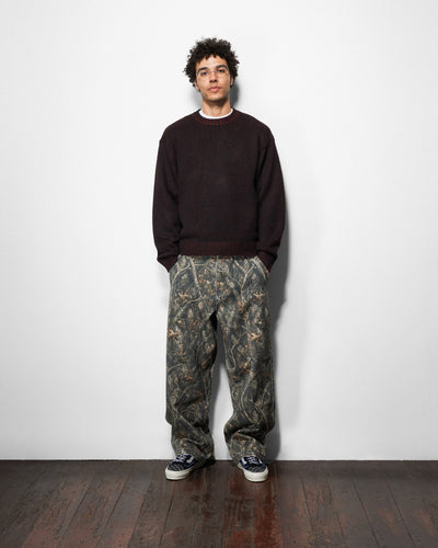 Butter Goods Work Pants in Forest Camo worn by a model