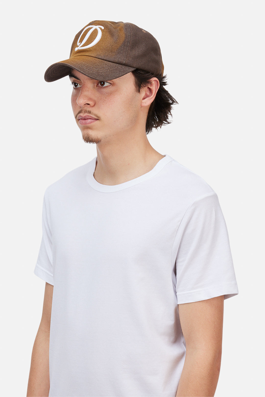 Model wearing the Dime MTL Cursive Denim Worker Cap in Brown Washed, side view