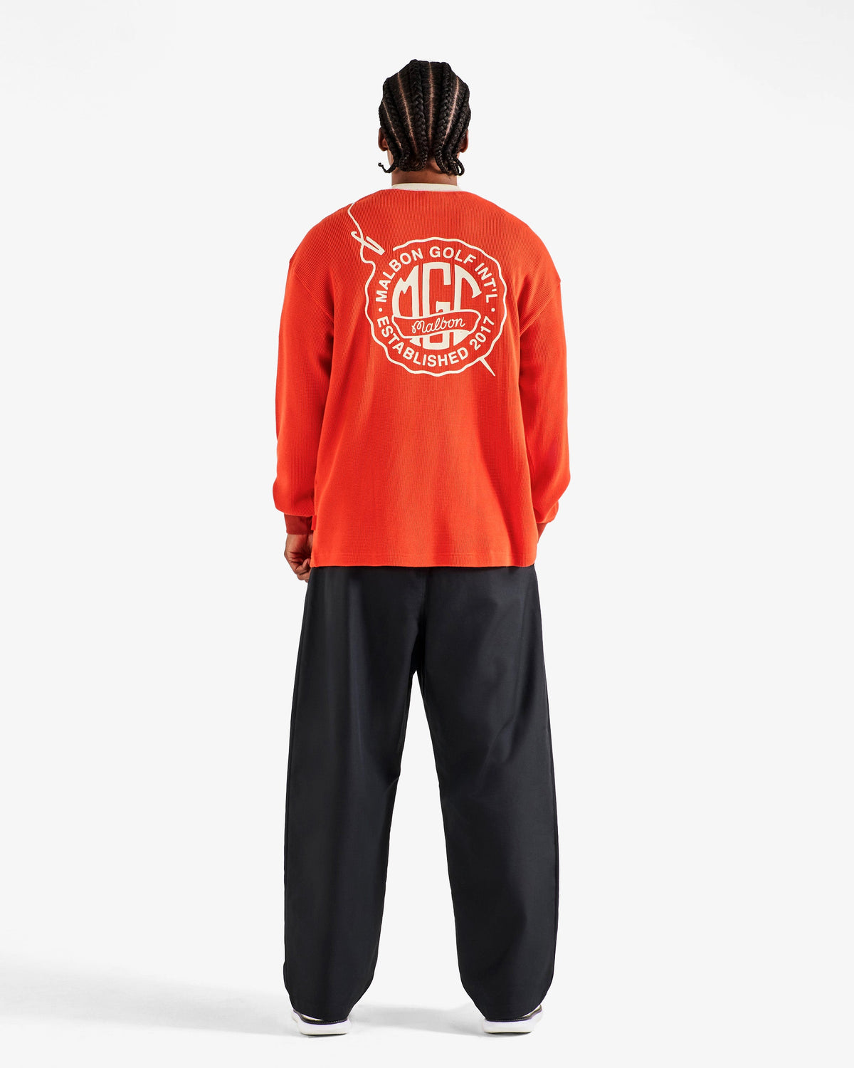 Back view of the Malbon Golf Gorse Heritage Long Sleeve in orange red showing the oversized Malbon Golf Int'l crest graphic across the shoulders