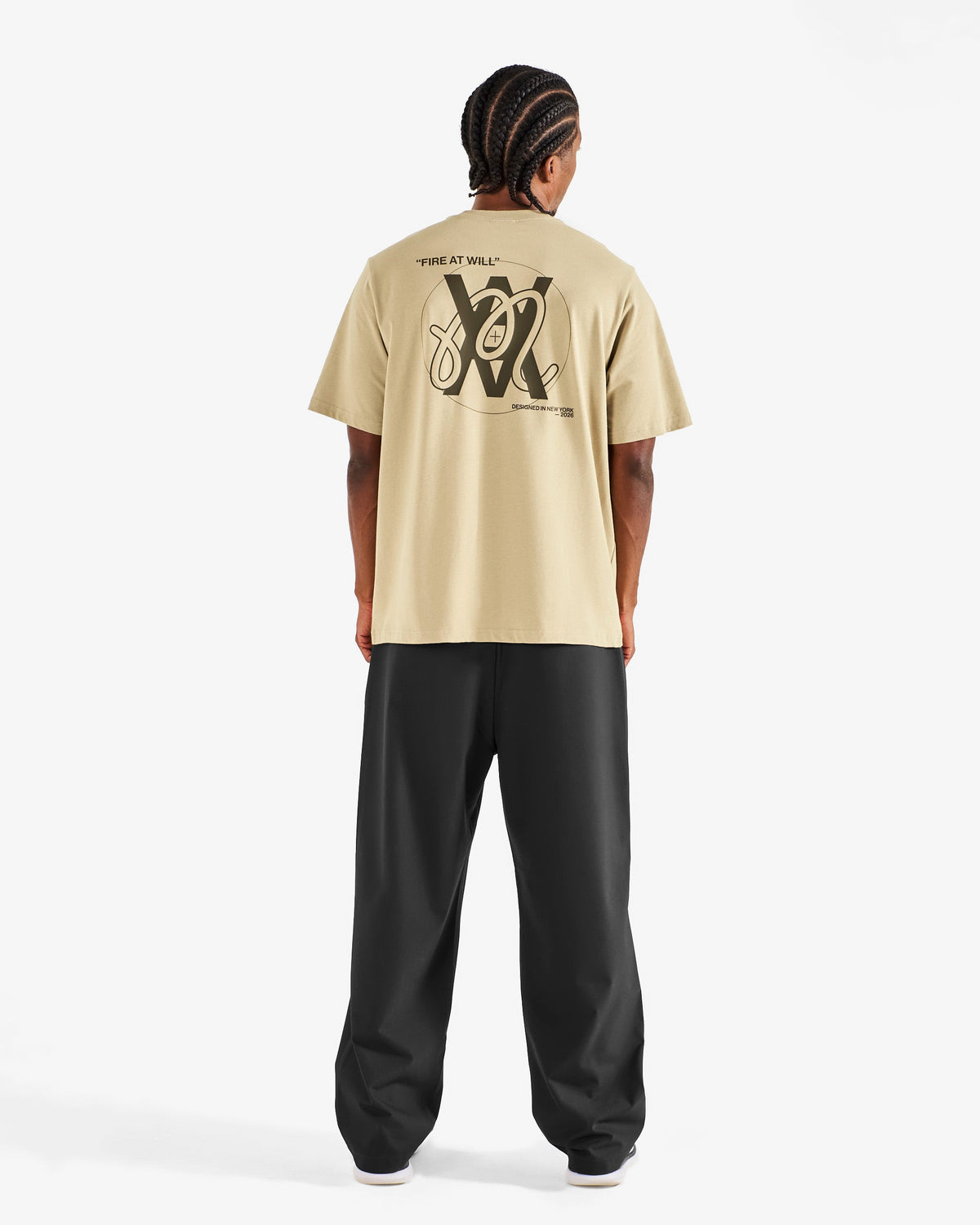 Malbon Golf x Daniel Arsham Bermuda Glyph Tee – Dune worn on model — beige cotton tee with Arsham glyph graphic, Gallery Streetwear Canada